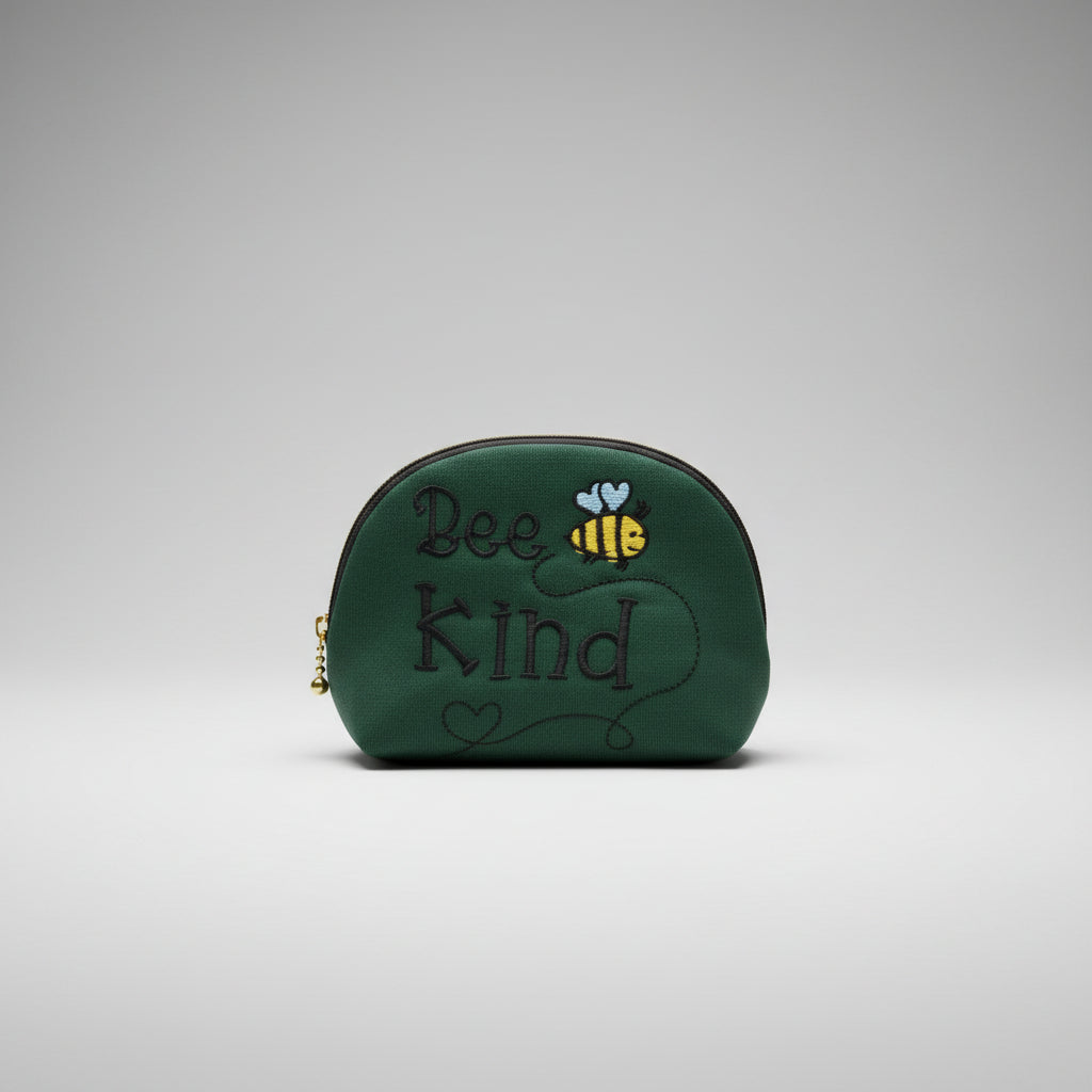 Green cap with 'Bee Kind' text and a bee design on a cutting mat.