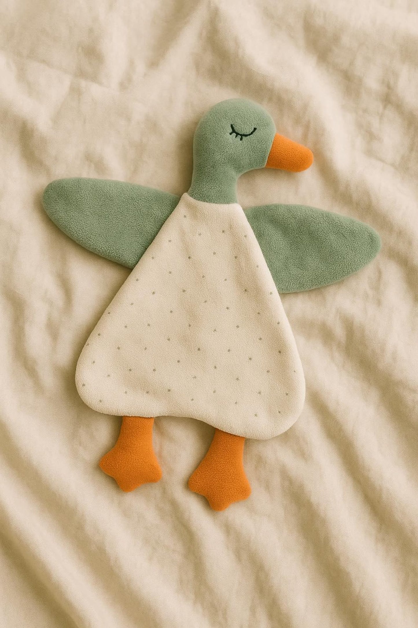 Plush toy duck on a beige fabric background