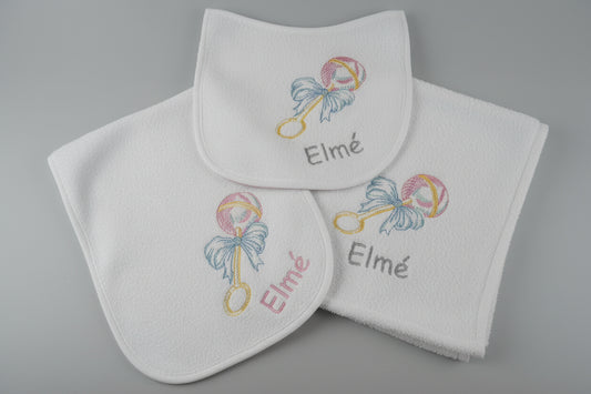Baby bib and towel set with 'Elmé' embroidery on a textured surface