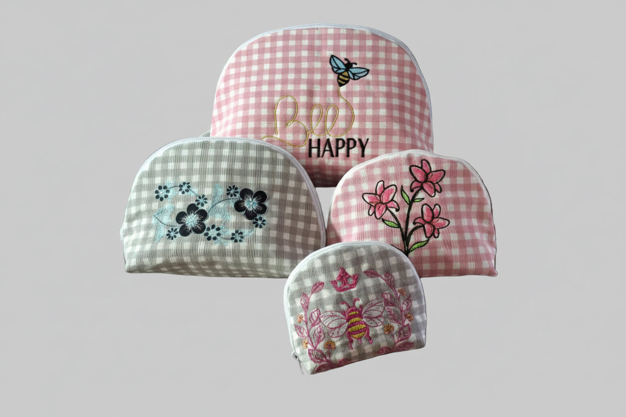 Set of embroidered fabric pouches on a round stone surface with a checkered pattern and floral designs.